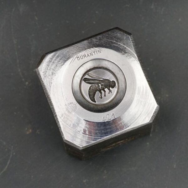 Mouche gravée dans un bloc d'acier